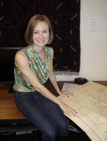 Photo Of Emily Hammer With Sitting In Front Of A Map