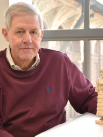 Photo Of Richard Zettler Sitting With An Ancient Statue On A Table In Front Of Him