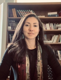 Photo of Huda Fakhreddine Standing In Front Of A Bookshelf